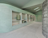 Modern interior with light green walls and white shelves.
