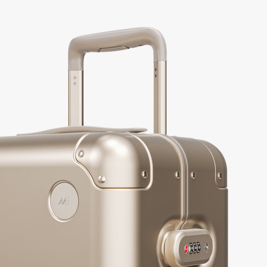 Champagne Gold | Luggage handle view of Aluminum Carry-On Plus in Champagne Gold