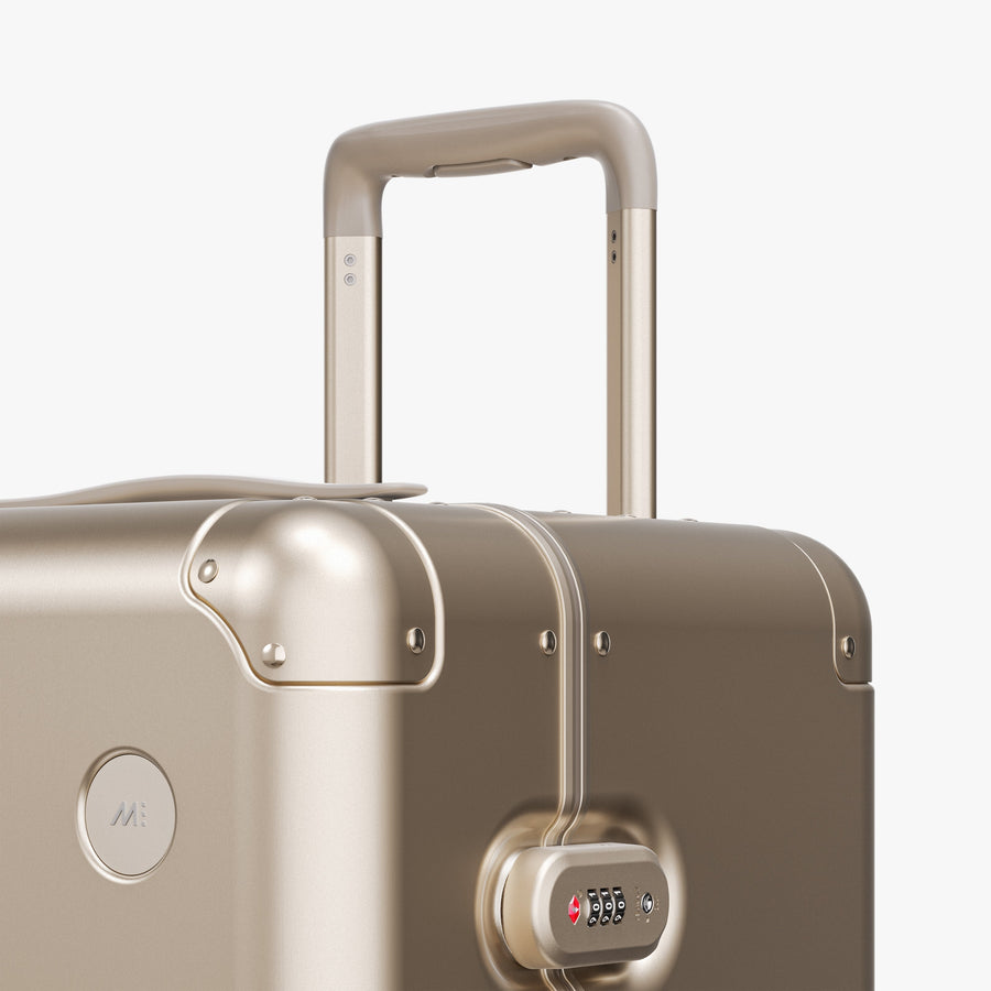 Champagne Gold | Luggage handle view of Aluminum Trunk in Champagne Gold