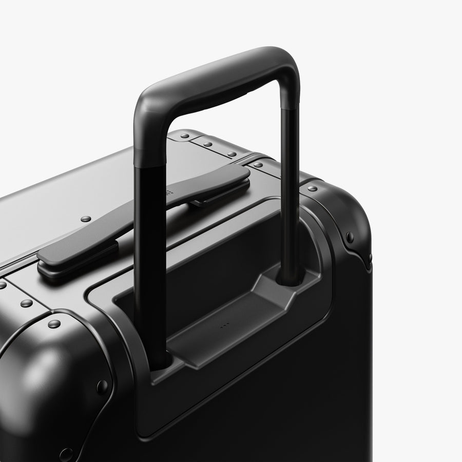 Caviar Black | Extended luggage handle view of Aluminum Carry-On Plus in Caviar Black