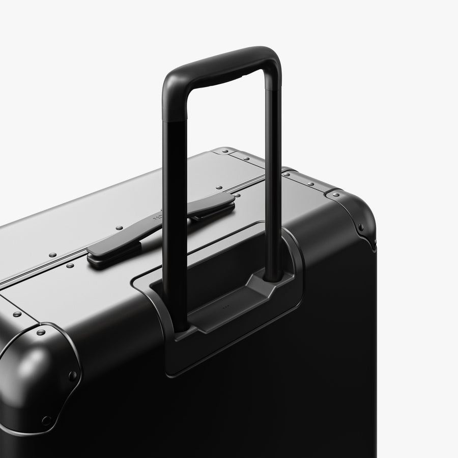 Caviar Black | Extended luggage handle view of Aluminum Check-In Large in Caviar Black