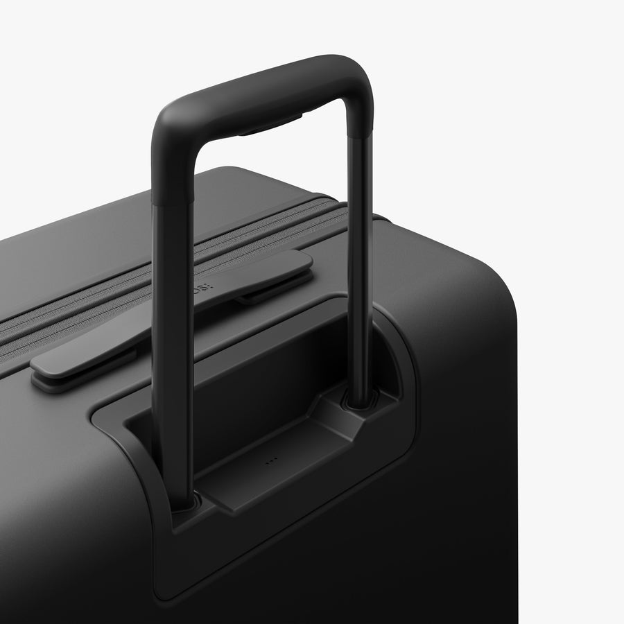 Midnight Black | Extended luggage handle view of Expandable Check-In Medium in Midnight Black