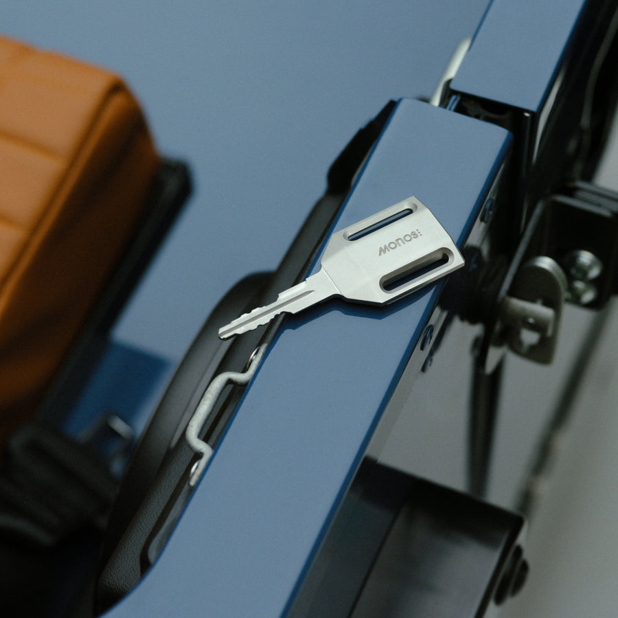 Arles Blue | Land Rover Defender key engraved with Monos logo resting on door frame