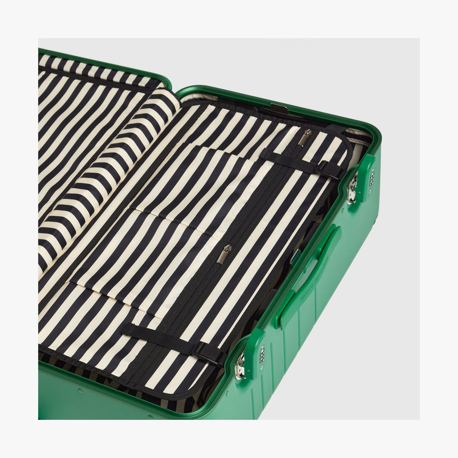 Jungle Green | Interior view of a Hybrid suitcase in Jungle Green featuring the Poplin Stripe Jungle Green compression pad with adjustable straps