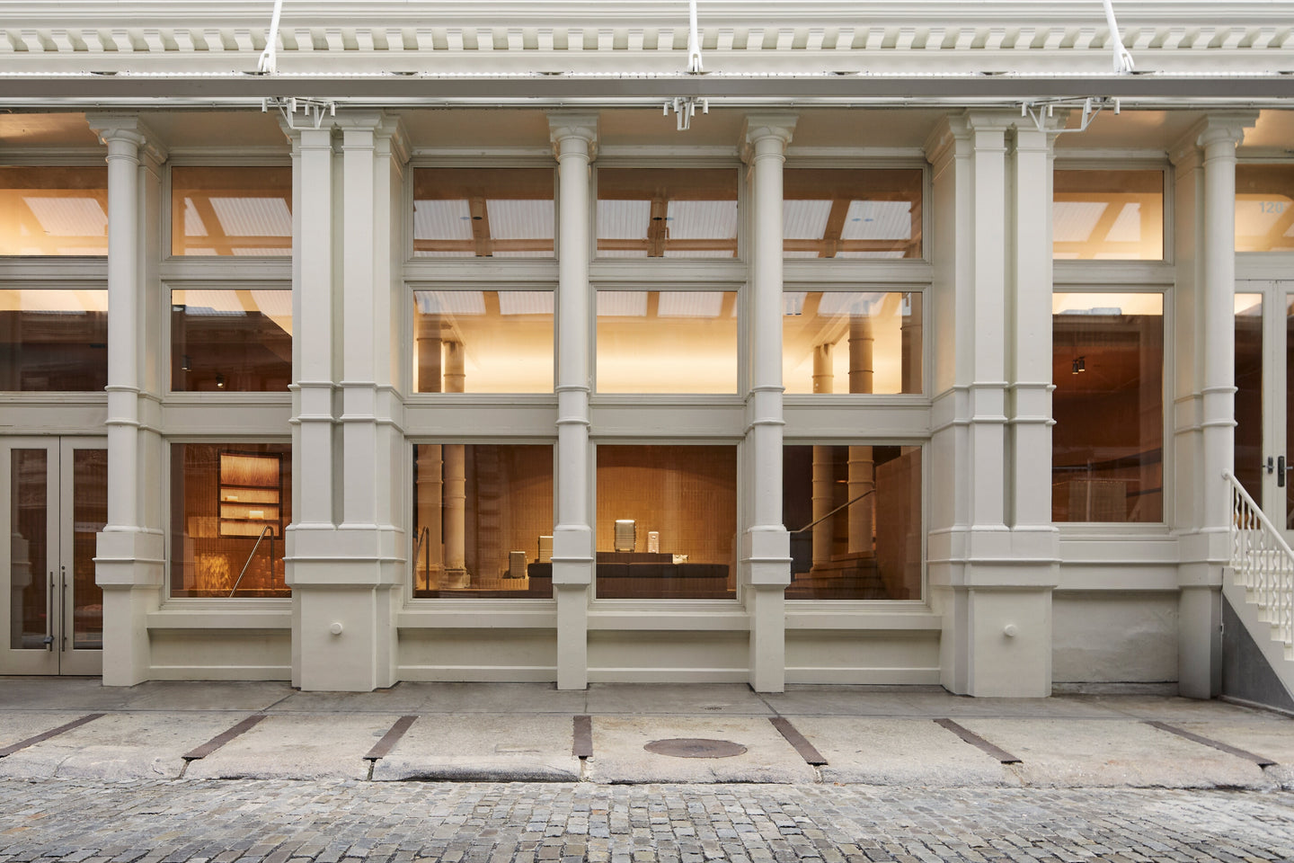 Monos SoHo store exterior in New York City with tall columns and large windows.
