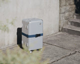 Monos suitcase with Luggage Strap in Ocean Blue under natural sunlight.