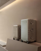 Monos Hybrid Collection luggage displayed on a pedestal inside the Boston store’s minimalist interior.